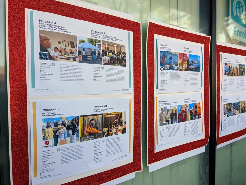 two boards on a wall bordered in red depict ballot measures with pictures and text